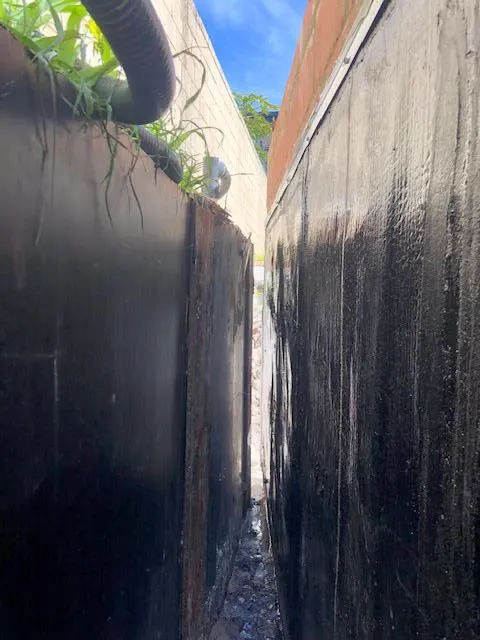 Bituminous waterproofing membrane on basement retaining walls before backfilling