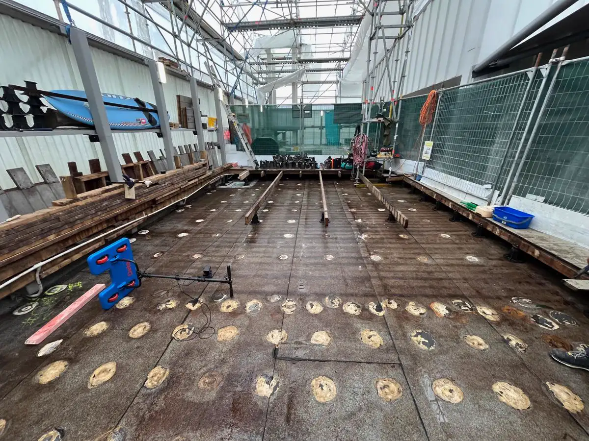 Detec electronic leak detection scanning platform on a torch-on roof membrane, with tested areas marked