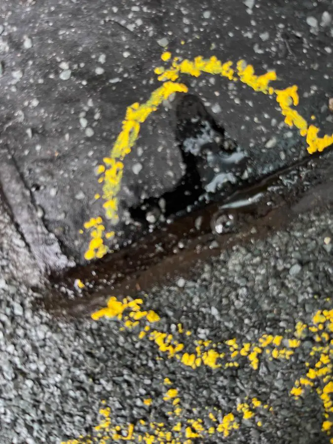 Close-up of a breach in a waterproofing membrane at a lap joint, circled in yellow marker paint